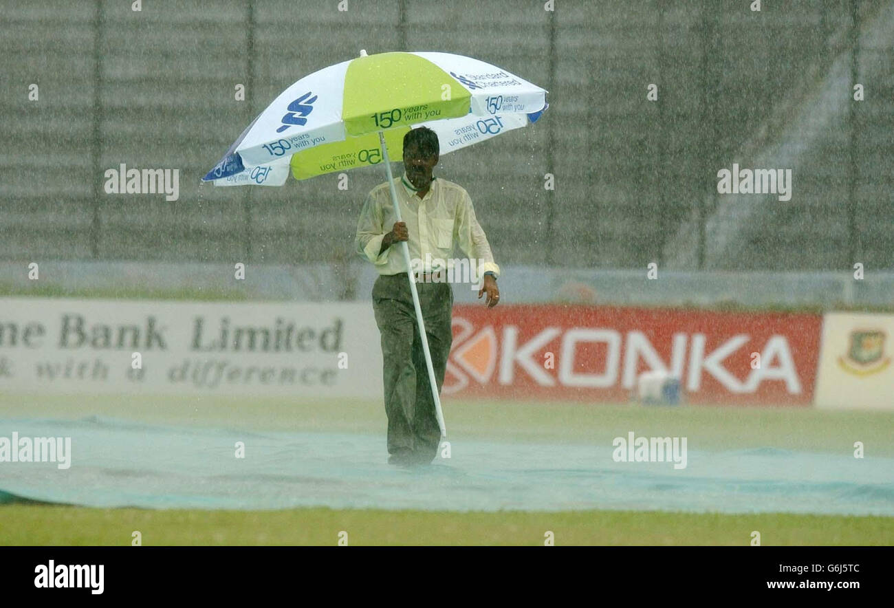 Ground staff at the Bangabandhu Stadium in Dhaka battle against torrential rain, after play in the inaugural Test between England and Bangladesh was halted after less than 20 minutes. Bangladesh had faced only four overs after winning the toss and deciding to bat and had reached one without loss when the storms broke over the ground and sent the players scurrying for the dressing rooms. Stock Photo