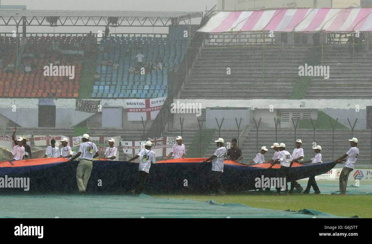 Ground staff at the Bangabandhu Stadium in Dhaka battle against torrential rain, after play in the inaugural Test between England and Bangladesh was halted after less than 20 minutes. Bangladesh had faced only four overs after winning the toss and deciding to bat and had reached one without loss when the storms broke over the ground and sent the players scurrying for the dressing rooms. Stock Photo