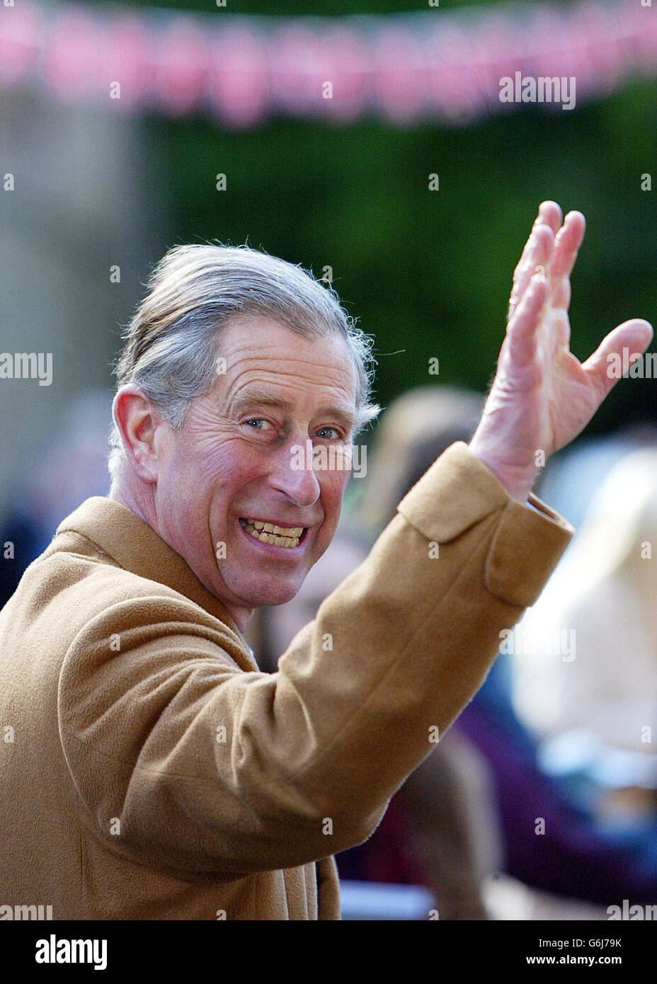 The Prince of Wales waves to the crowds gathered at Pendle Heritage Centre in the village of Barrowford, Lancashire, where he met Sir Roger Bannister - who almost 50 years ago became the first athlete to run a sub-four minute mile - at Park Hill House, where a cross-section of the building is on show allowing visitors to see how the buildings were constructed. Stock Photo