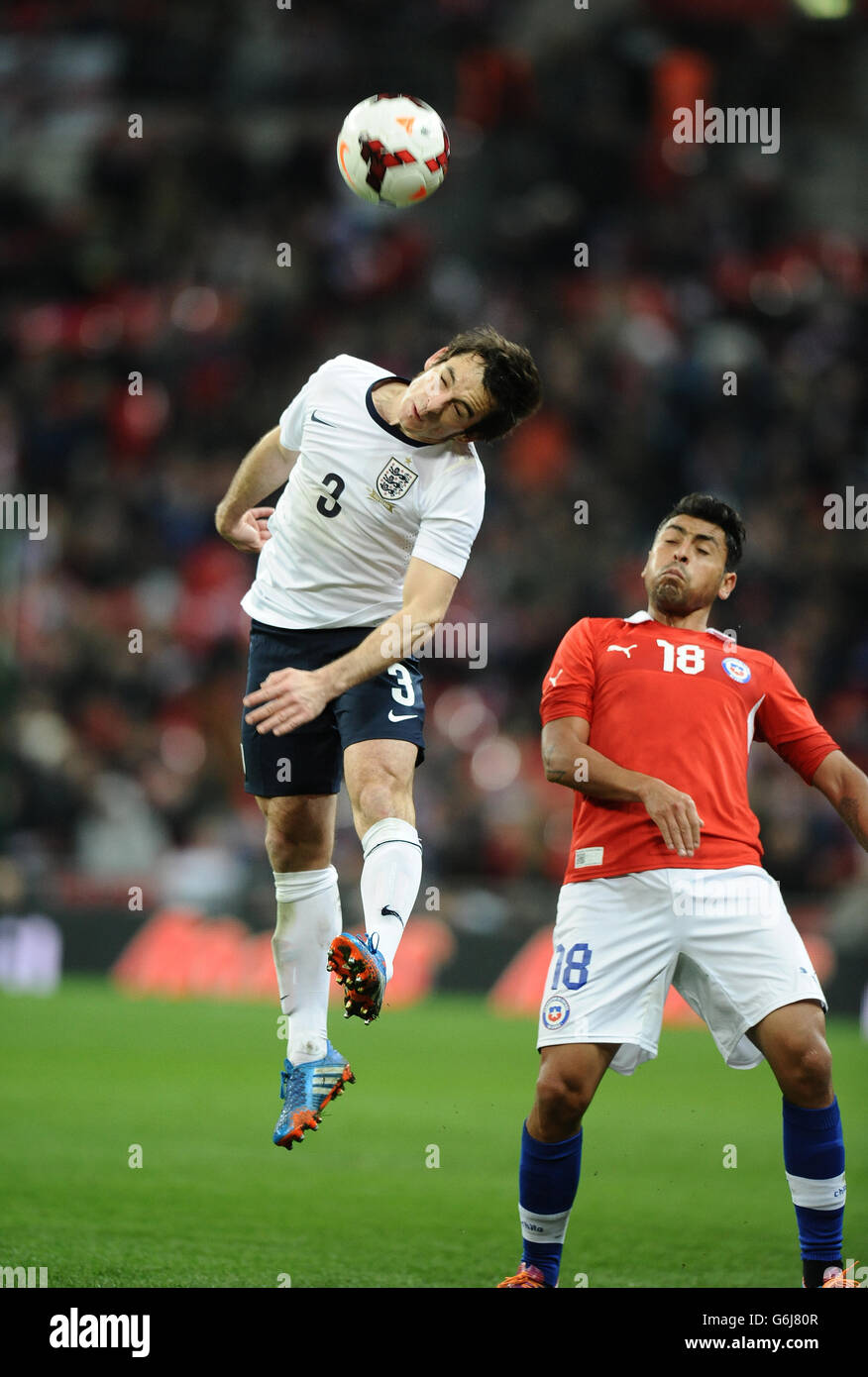 Soccer - International Friendly - England v Chile - Wembley Stadium. England's Leighton Baines wins the ball in air from Chile's Gonzalo Jara Stock Photo