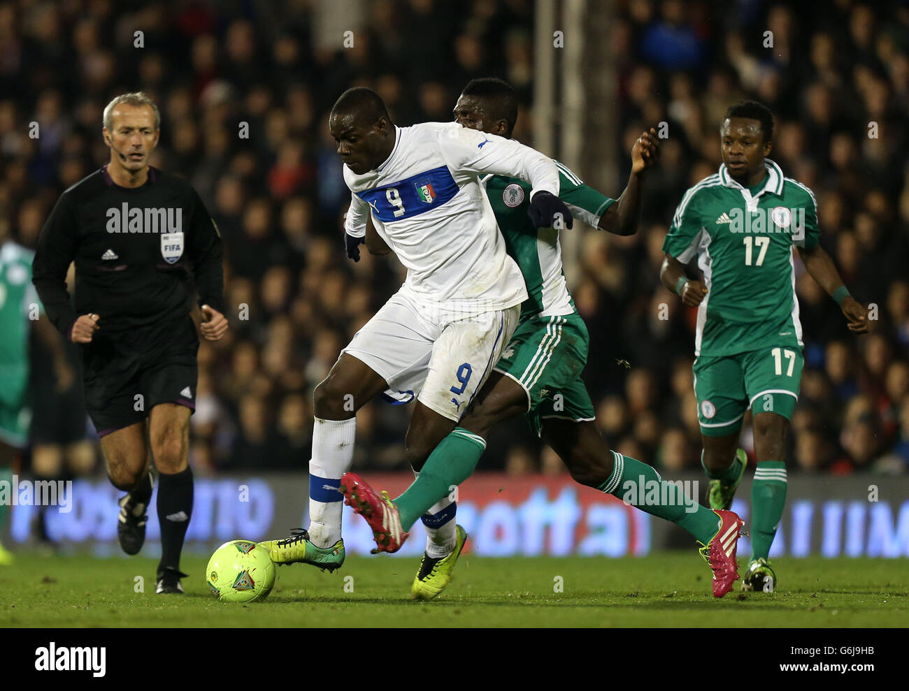 Italy's Mario Balotelli (left) is tackled by Nigeria's John Ogu during the International Friendly at Craven Cottage, London. Stock Photo