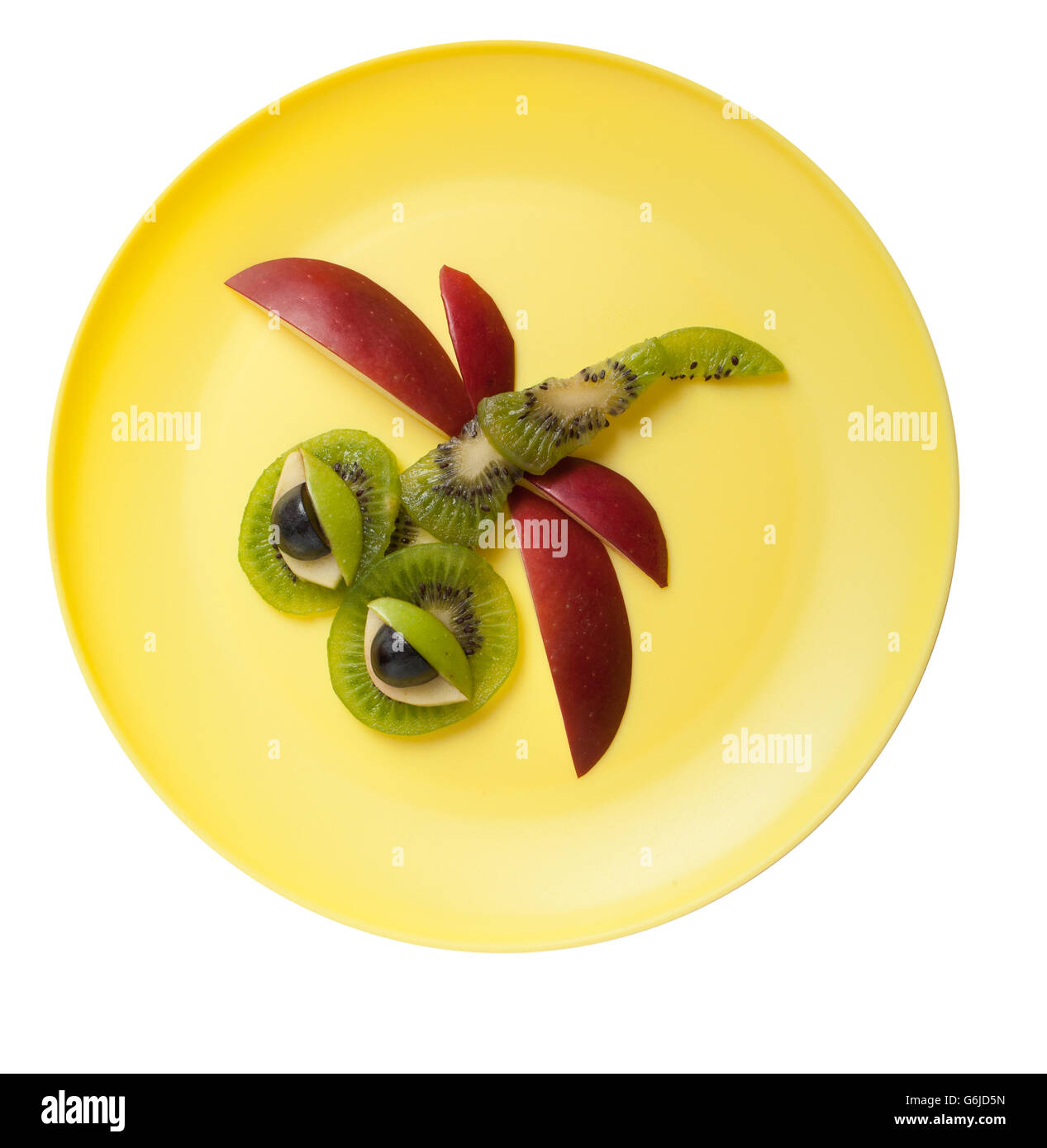 Amusing dragonfly made of fruits on yellow plate Stock Photo