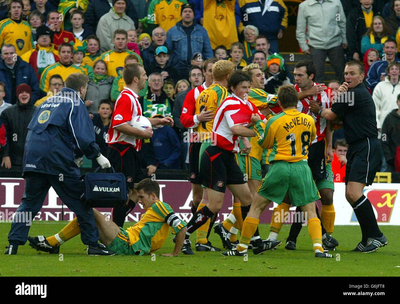 Norwich and Sunderland players fight on the pitch as Adam Drury sits