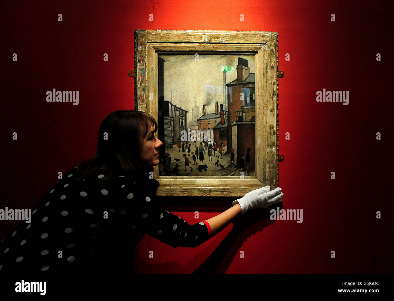 Fine Arts Assistant Amanda Askari, positions LS Lowry's Houses Near a Mill painting which was bought by the Derby Museum and Art Gallery, Derby, for £42 in 1946 and is now thought to be worth in the region of £1 million. Stock Photo