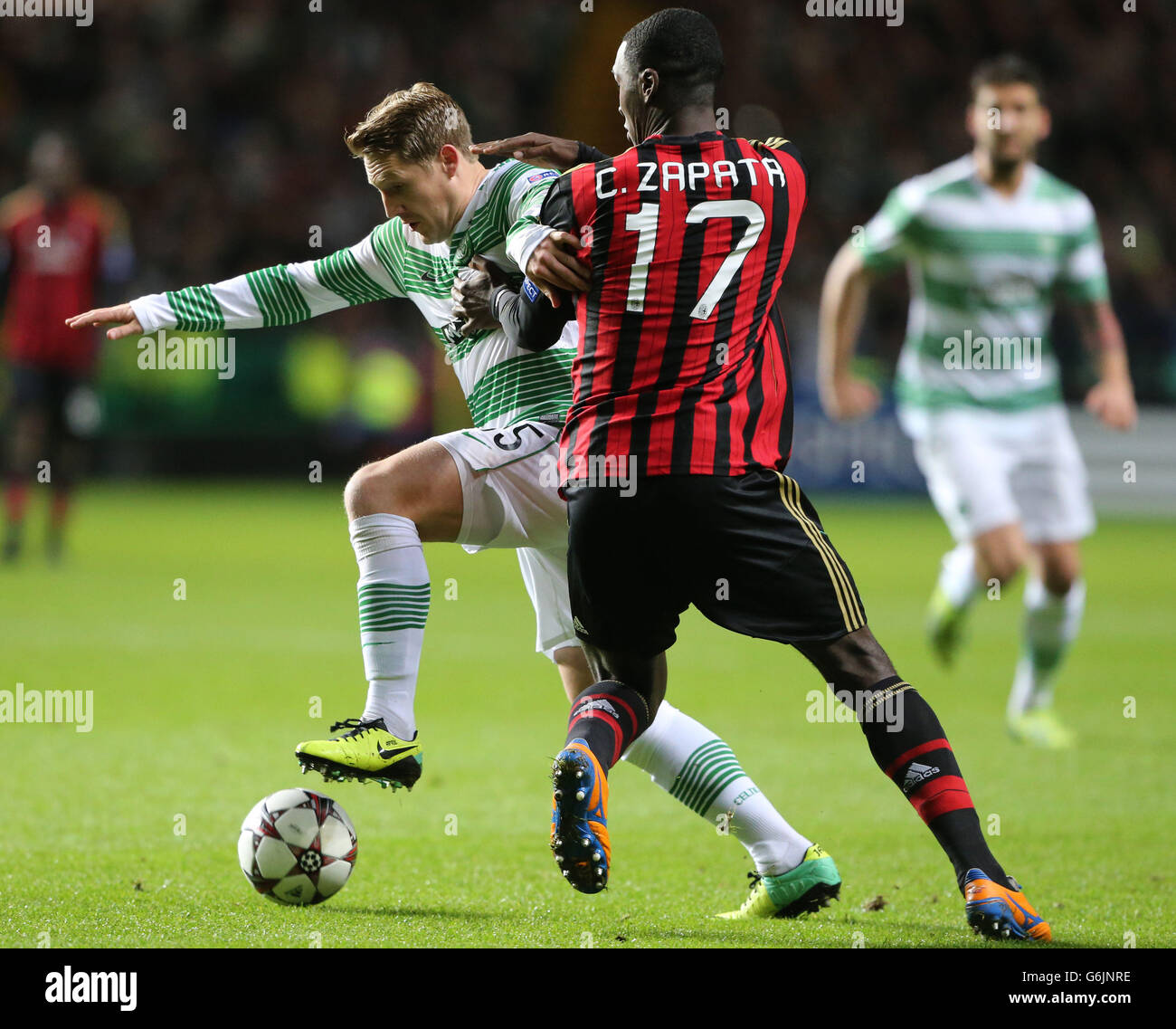 Celtic's Kris Commons challenges AC Milan's Cristian Zapata (right) during the UEFA Champions League match at Celtic Park, Glasgow. Stock Photo