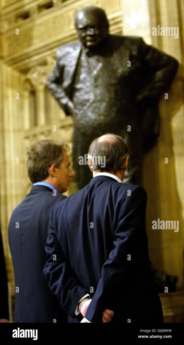 Prime Minister, Tony Blair, and the leader of the opposition, Michael Howard, walk past a statue of Winston Chaurchill after the State Opening of Parliament in London. Britain's Queen Elizabeth II, seated on the Throne in the House of Lords, formally announced the UK Government's legislative programme for the new parliamentary session. Stock Photo