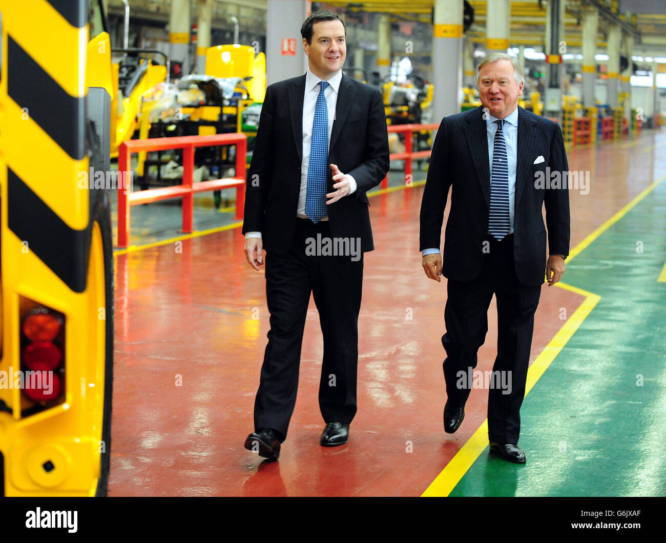 The Chancellor of the Exchequer George Osborne with JCB Chairman Lord Bamford (right) during a visit to JCB's backhoe loader factory in Rocester, Staffordshire. JCB announced today plans to invest &pound;150 million to expand its operations in Staffordshire and create an additional 2.500 jobs by 2018. Stock Photo