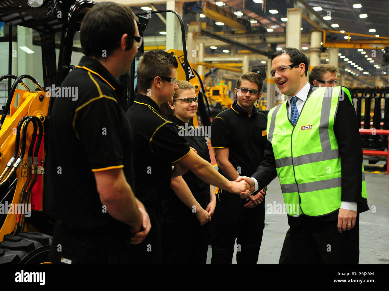The Chancellor of the Exchequer George Osborne meets apprentices during a visit to JCB's backhoe loader factory in Rocester, Staffordshire. JCB announced today plans to invest £150 million to expand its operations in Staffordshire and create an additional 2.500 jobs by 2018. Stock Photo