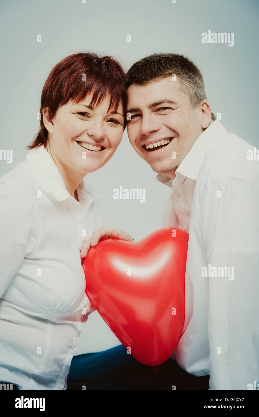 Couple with a heart-shaped balloon Stock Photo - Alamy