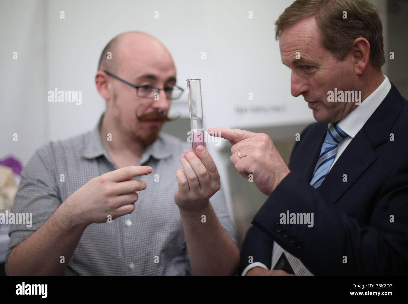Taoiseach Enda Kenny looks on as Scientist Conor Courtney conducts a DNA extraction experiment before he launched the programme of four new exhibitions for 2014 at Science Gallery at Trinity College. Stock Photo