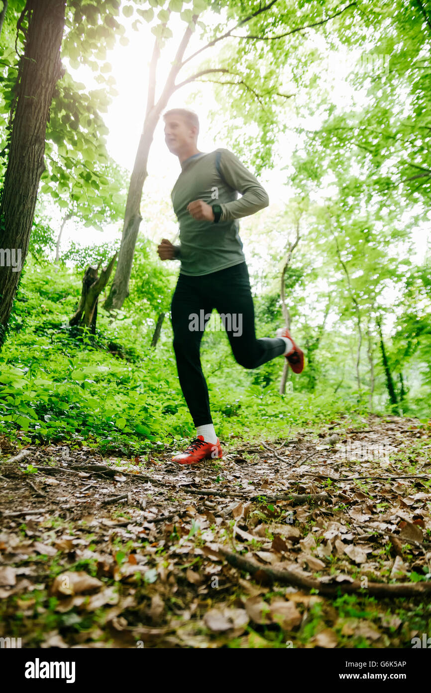 Young adult man running in a forest hi-res stock photography and images ...