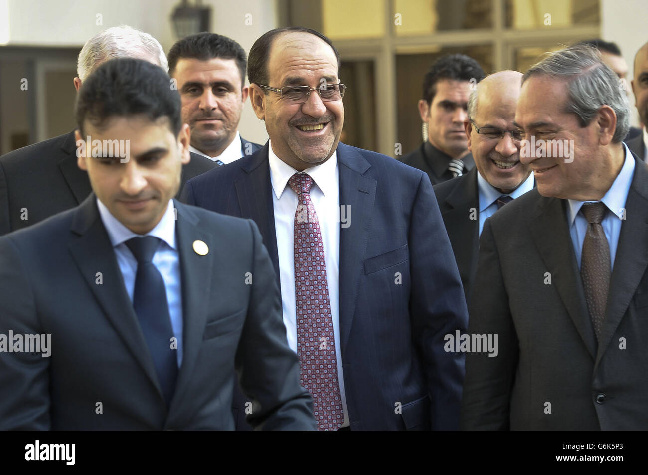 Iraq's Prime Minister Nouri Al-Maliki (centre) leaves following his official opening of the first branch of British bank Standard Chartered, in, Baghdad, Iraq, in what is being billed as a significant milestone in the country's recovery. Stock Photo