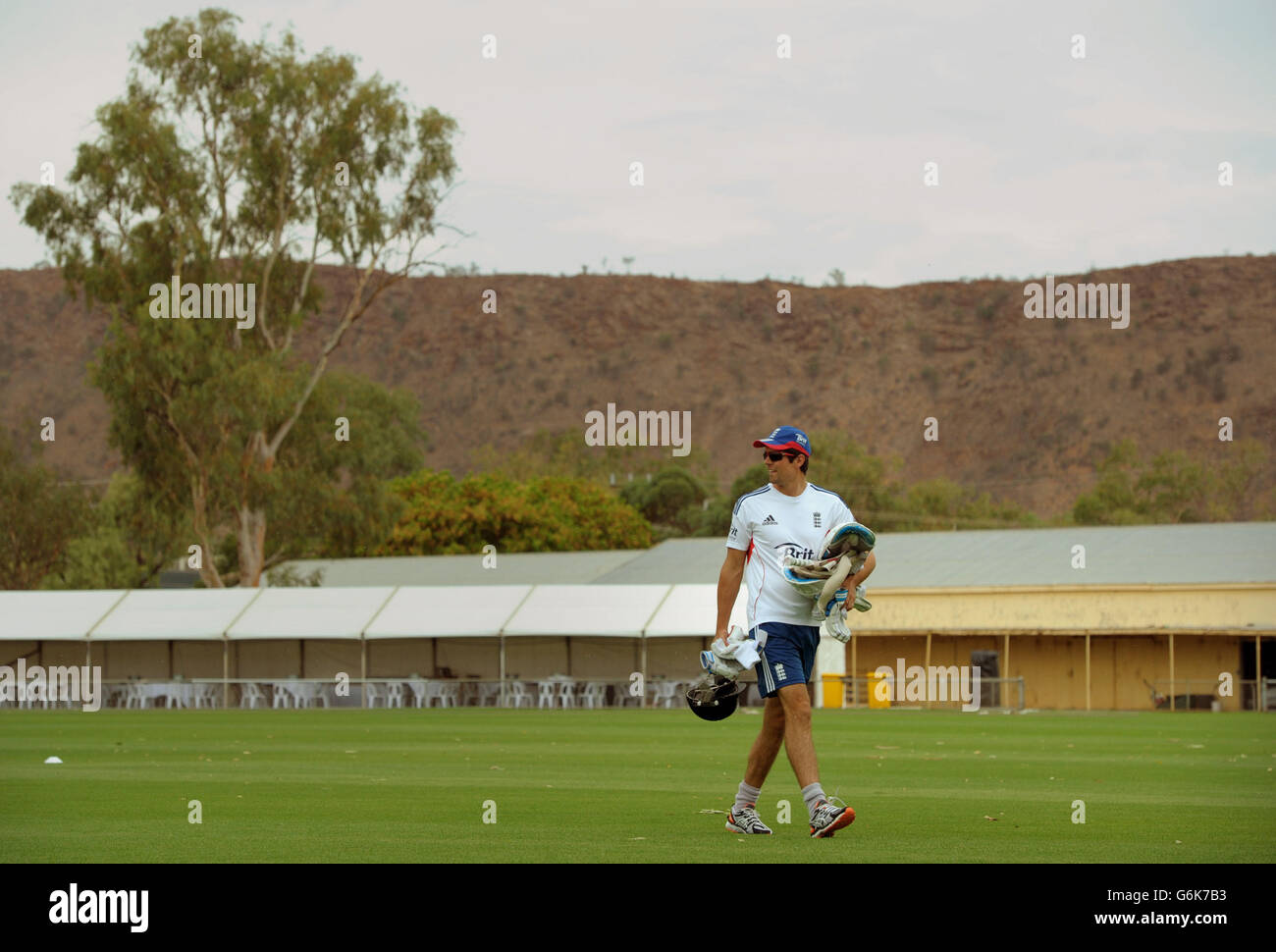 The MacDonnell mountains are seen in the background as England's Alastair Cook arrives during