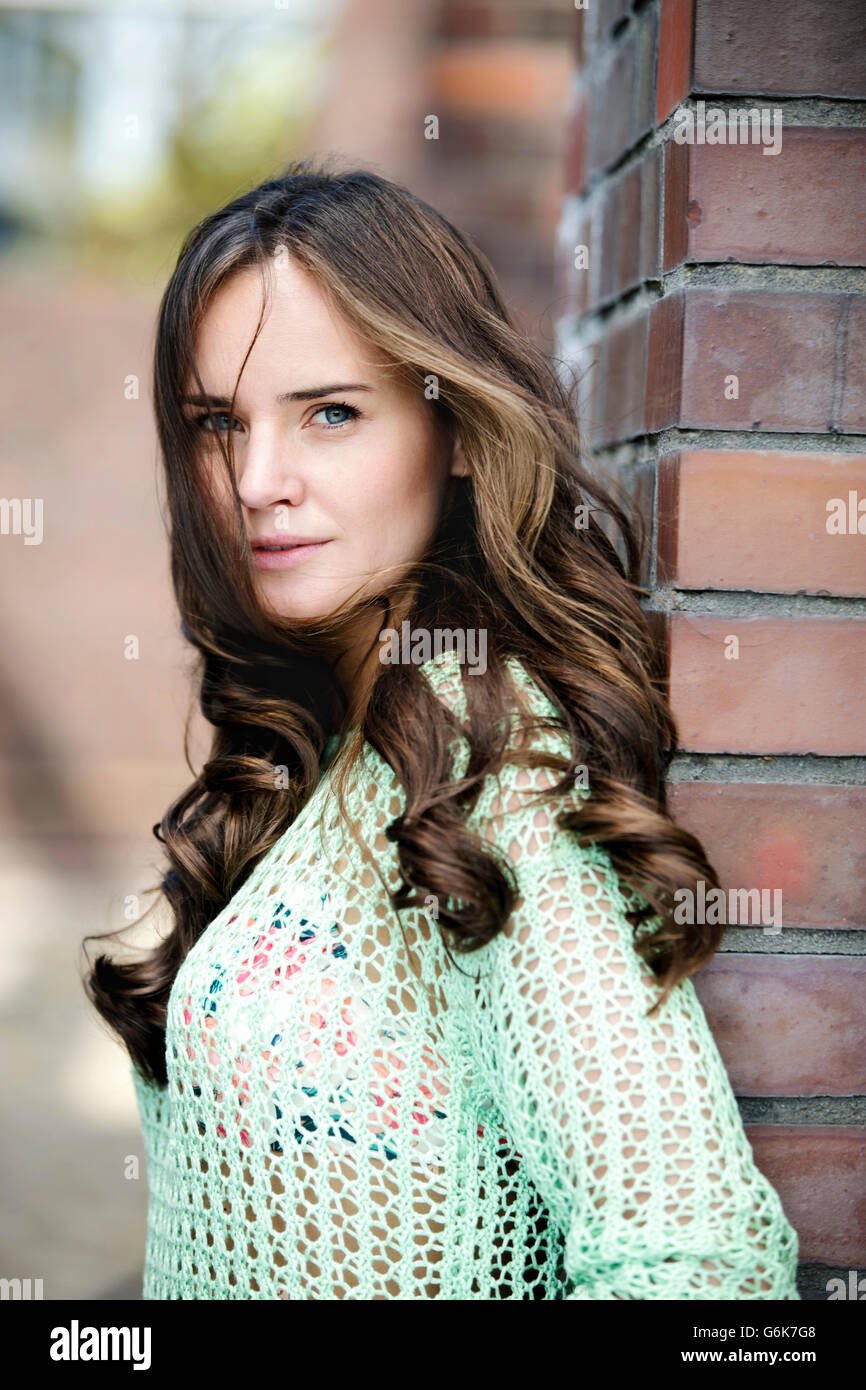 Portrait of smiling young woman with long brown hair Stock Photo - Alamy