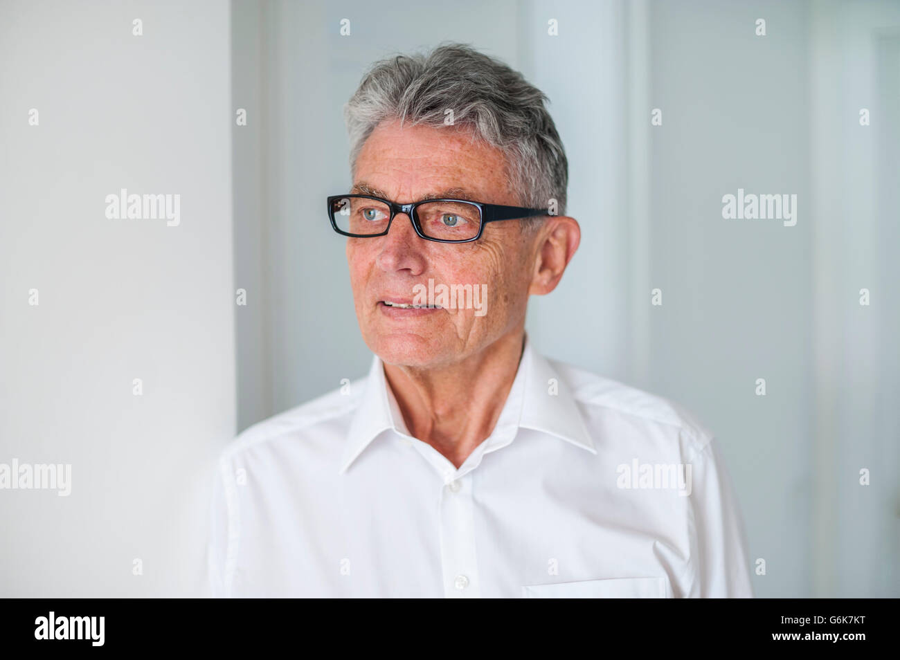 Senior man wearing glasses and white shirt Stock Photo