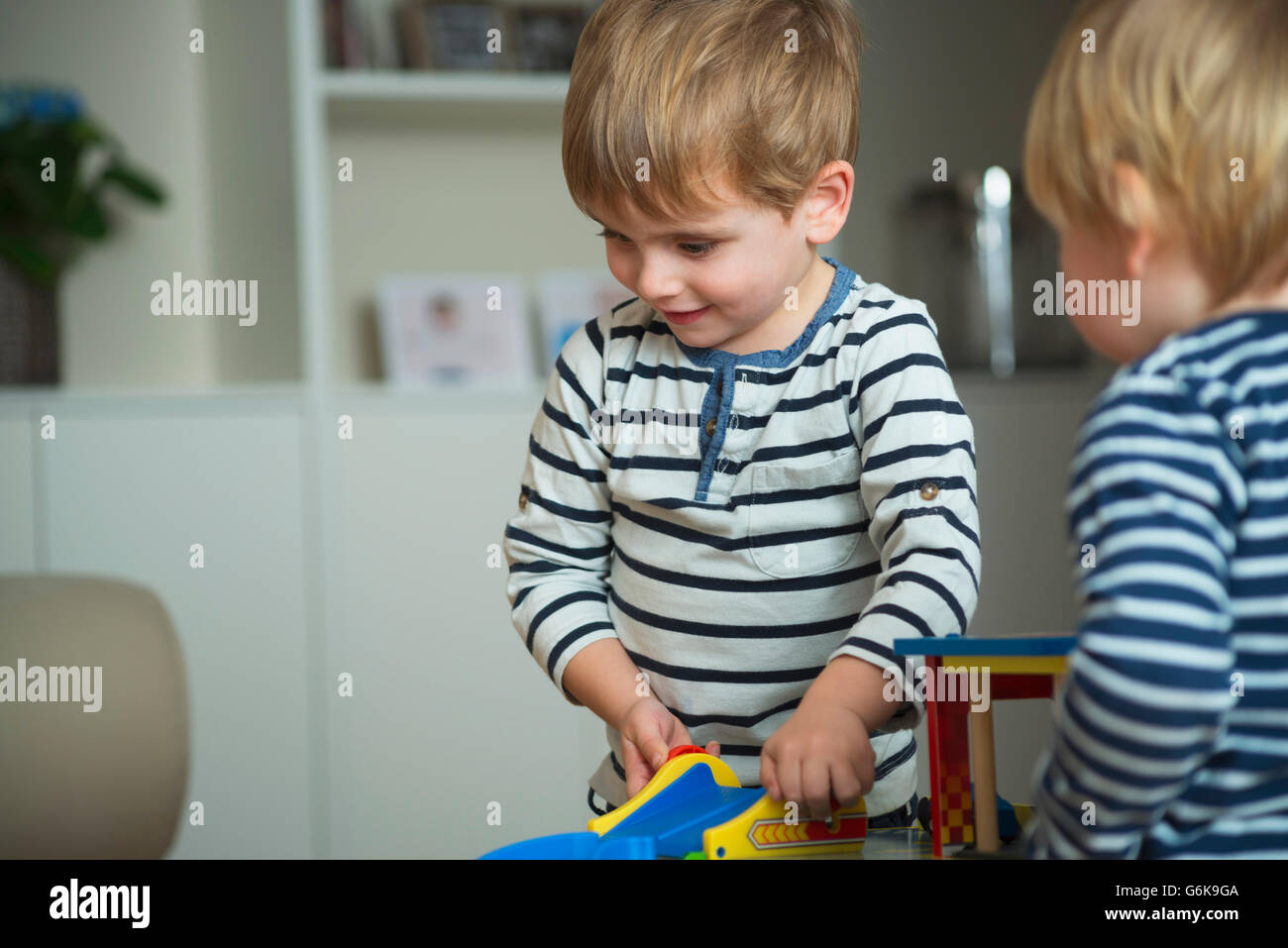 Two little boys playing at home with toys Stock Photo - Alamy