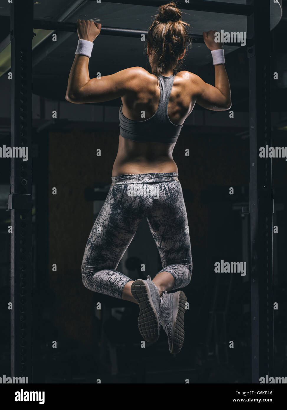 Female athlete exercising chin-ups Stock Photo