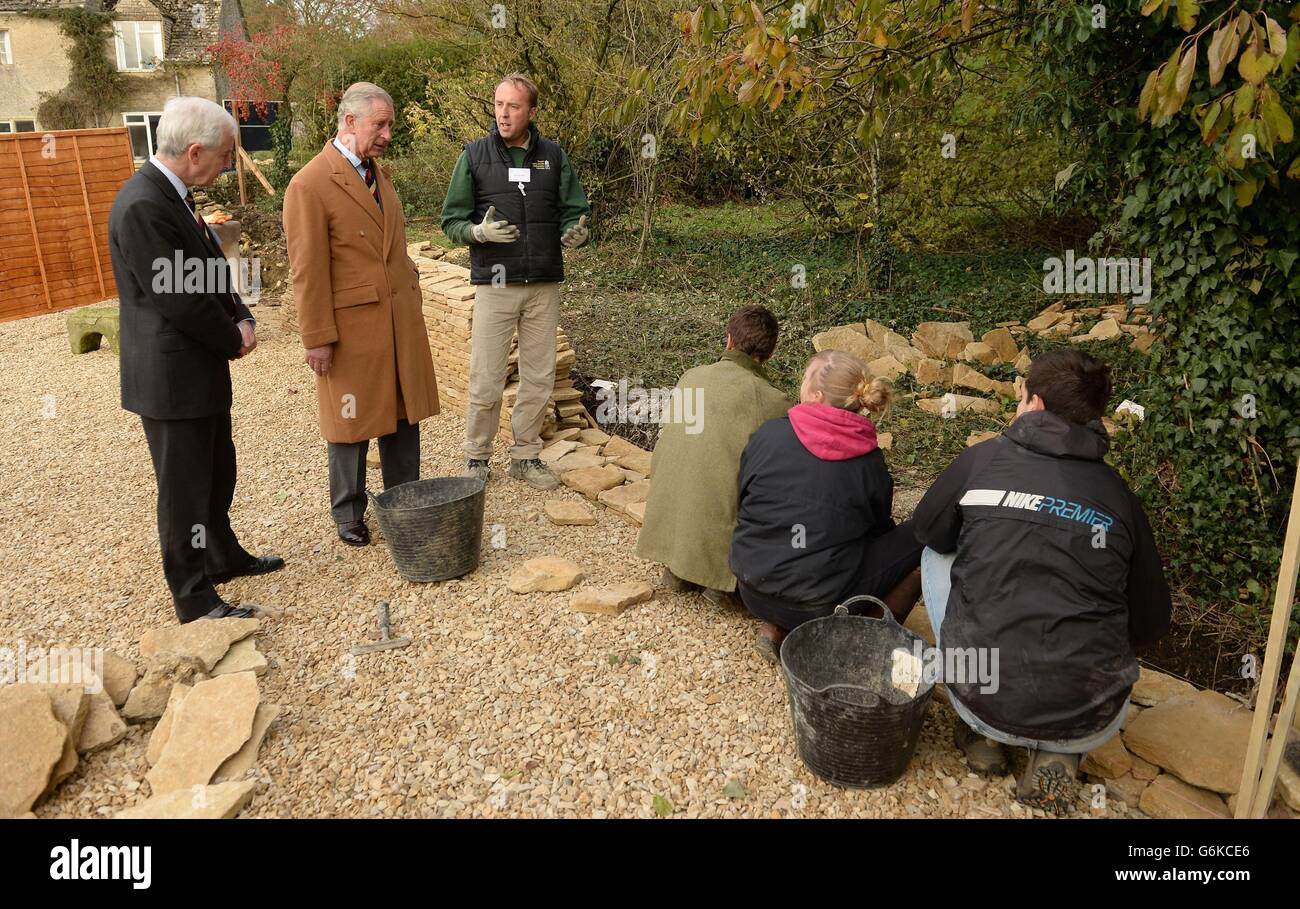 Royal Agricultural University Principal Professor Chris Gaskell (left) and the Prince of Wales (second left) are given a demonstration by Jon Bendle (third left) and students on building a dry stone wall during a visit to the University's Rural Innovation Centre at Manor Farm in Gloucestershire. Stock Photo