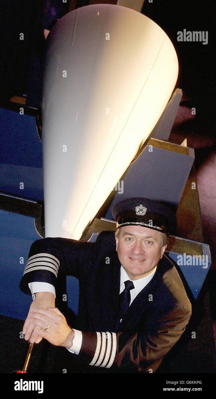 Chief Concorde Pilot Captain Mike Bannister poses with a nose cone at London's Olympia Exhibition Hall, before it is sold at auction as part of a sale of Concorde memorabilia, at Bonhams on Monday. Iconic memorabilia, such as the captain's seat and a machmeter, belonging to one of the 30-year-old aircraft that was retired from service recently, will be sold off, with funds raised donated to charity. Stock Photo