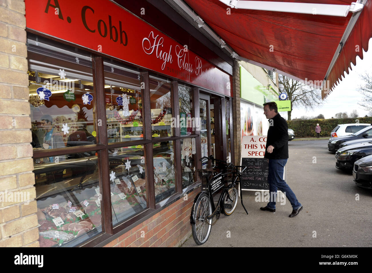 Prime Minister David Cameron enters a family butchers, A Cobb in Aylesbury, Buckinghamshire, as he marks 'Small Business Saturday' an initiative designed to encourage people to use local shops and businesses. Stock Photo