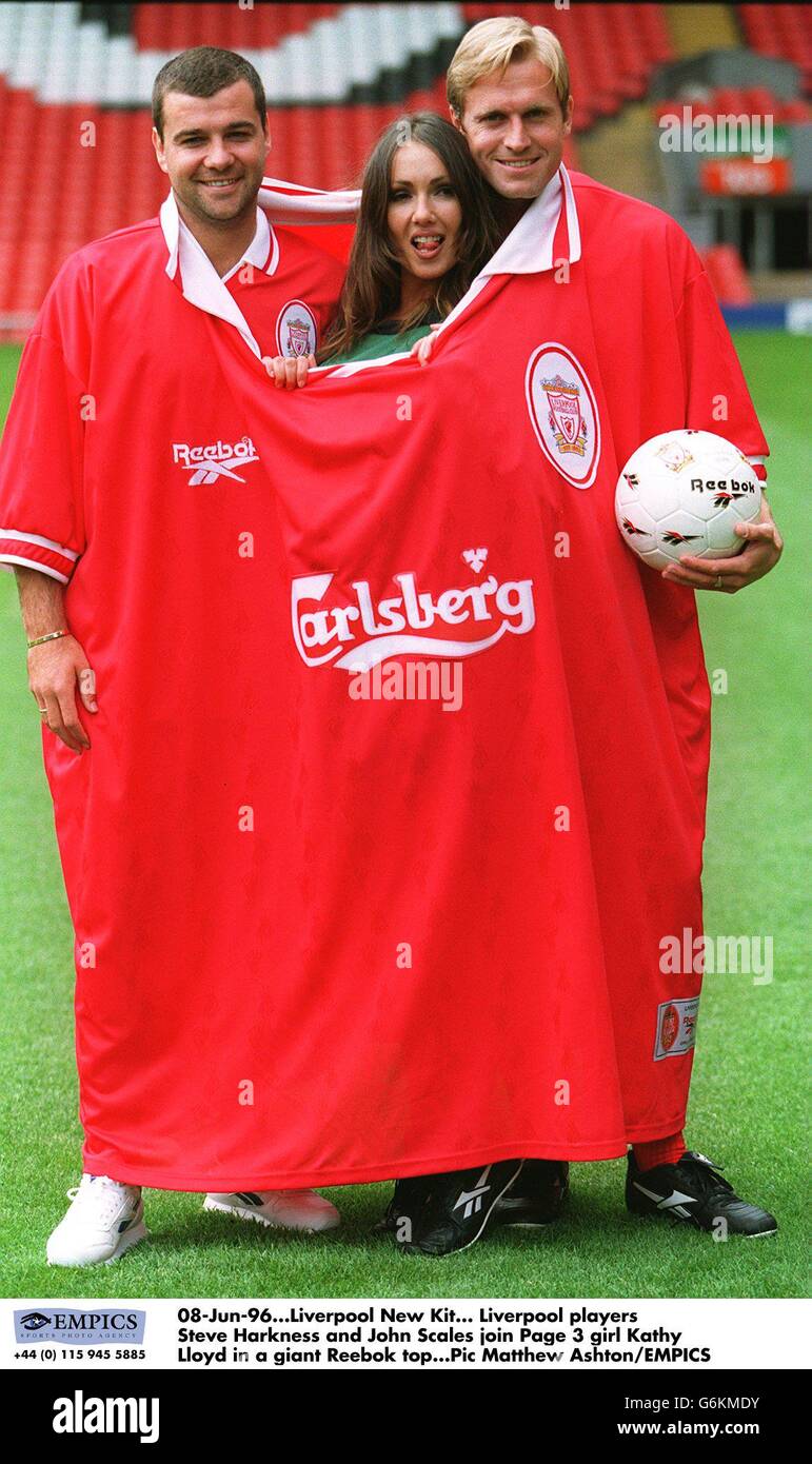 08-Jun-96. Liverpool New Kit. Liverpool players Steve Harkness and John Scales join Page 3 girl Kathy Lloyd in a giant Reebok top Stock Photo