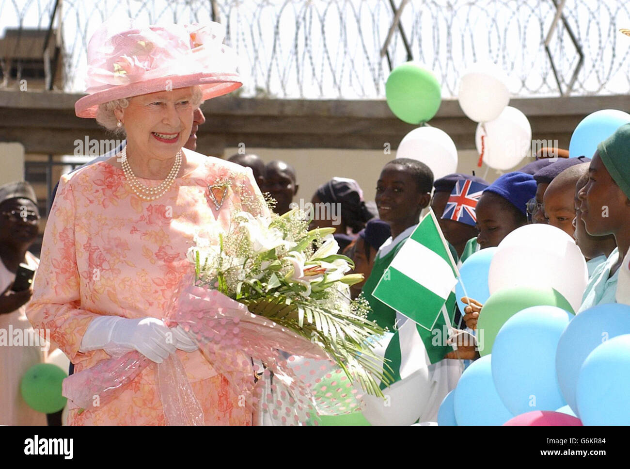 Queen Elizabeth II meets local school children inside the compound of the British Council, in Abuja, Nigeria, on the opening day of the Commonwealth Heads of Governments Meeting. Stock Photo