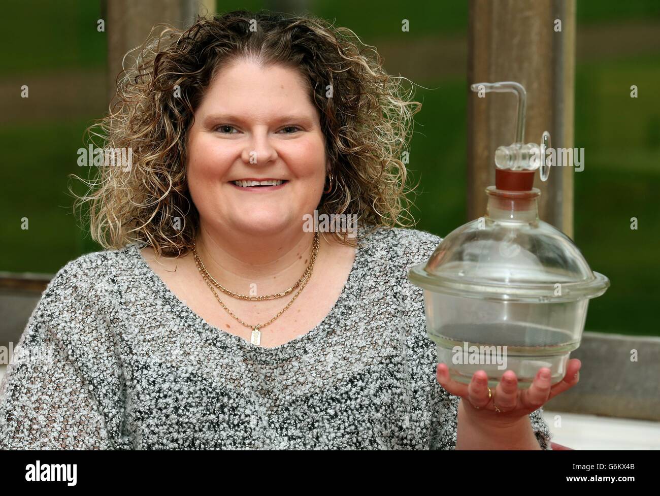 Louise Brown, the world's first test tube baby, holds the incubator jar in which her embryo was incubated, at the Bourne Clinic in Cambridgeshire, after planting a tree in memory of her mother and father who were the first parents to have a child using IVF. Stock Photo