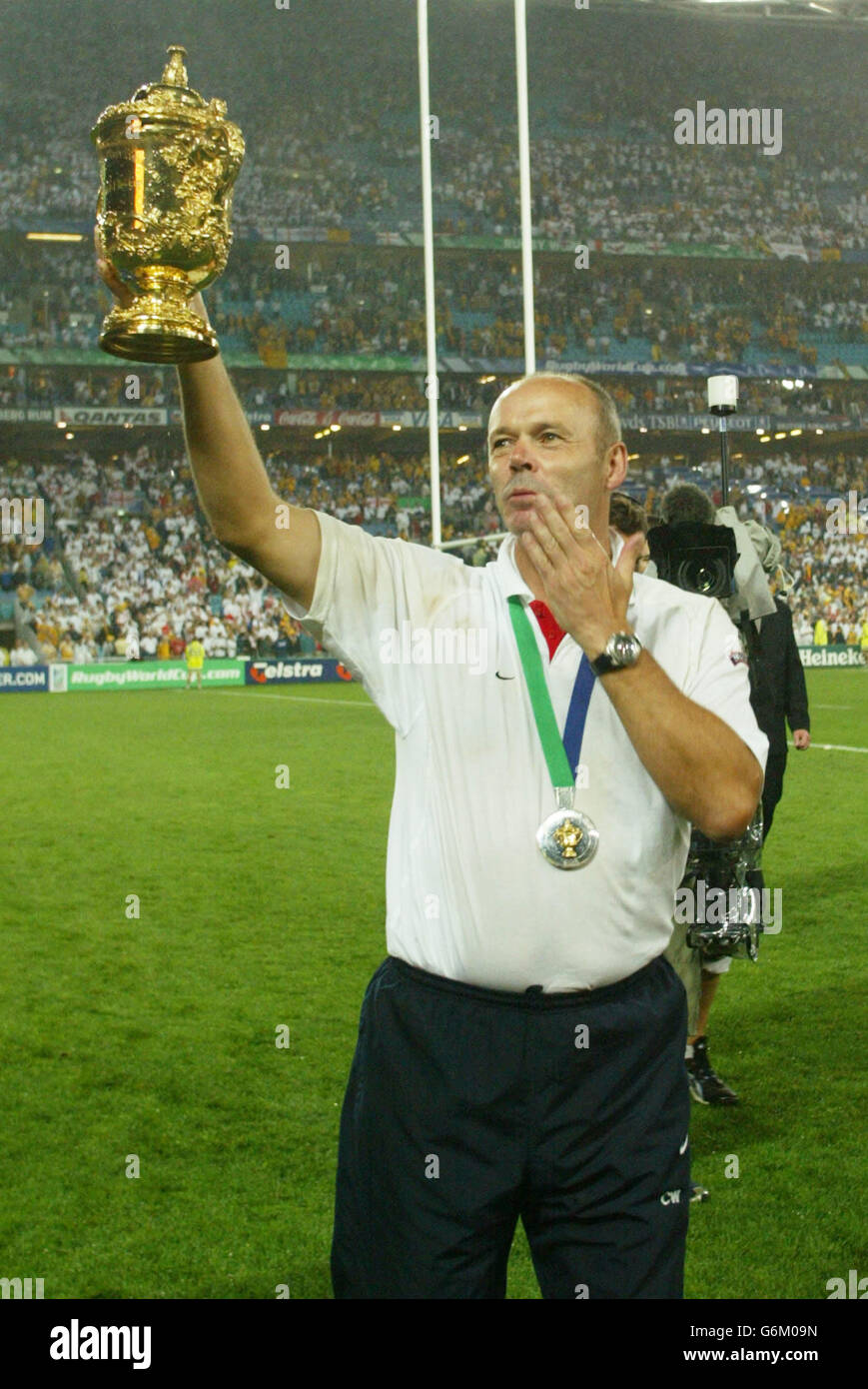 England coach Clive Woodward lifts the Webb Ellis trophy aloft after beating Australia in the Rugby World Cup Final at the Telstra Stadium, Sydney, Australia. No mobile phone use, Internet sites may only use one image every five minutes during match Stock Photo