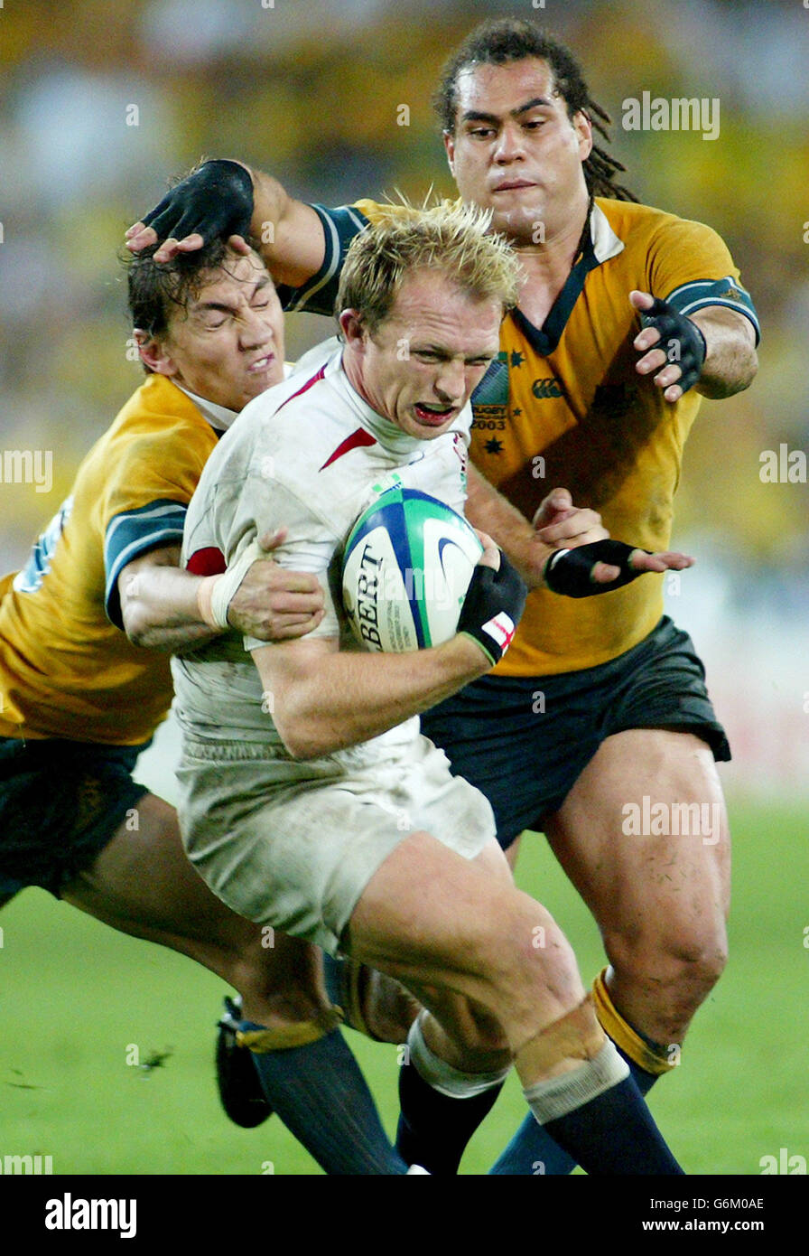 England's Matt Dawson (centre) charges throught the tackle from Australia's  Matt Rodgers (left) and George Smith during the Rugby World Cup Final at  the Telstra Stadium, Sydney, Australia. England won the final