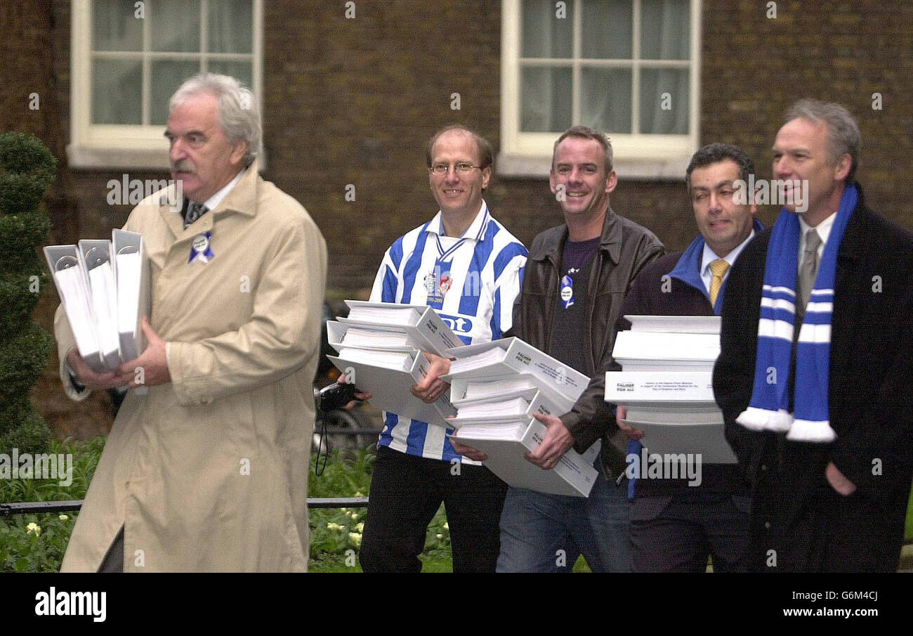 TV football host Des Lynam, left, and DJ Norman Cook, aka Fatboy Slim, centre, arrive in Downing Street with fellow supporters, from second left, Tim Carder, Paul Samrah and Lord Bassam of Brighton, to deliver a 62,000 signature petition requesting Government approval for a new stadium for their beloved Brighton and Hove Albion FC. The Second Division club, who currently play at an athletics stadium at Withdean, want to build a multi-purpose 25,000-seat stadium at Falmer. Stock Photo