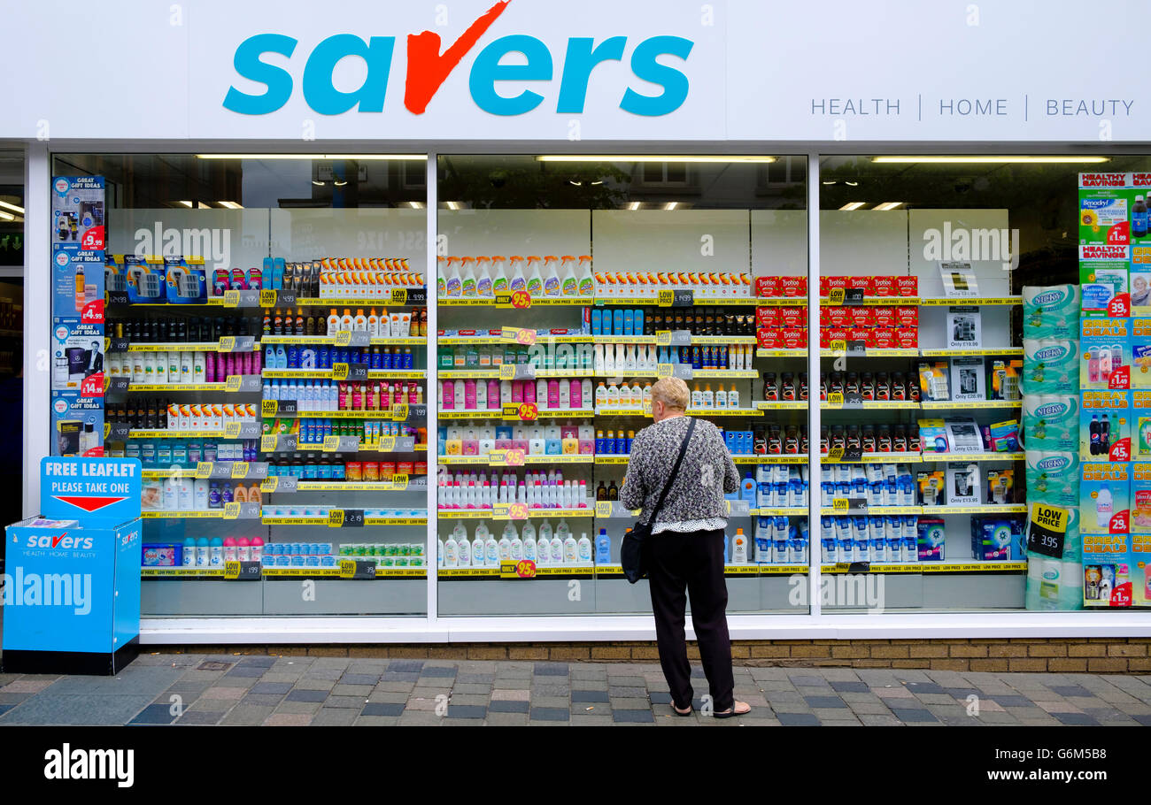 Woman window shopping in budget shop  Savers, in Glasgow Scotland United Kingdom Stock Photo