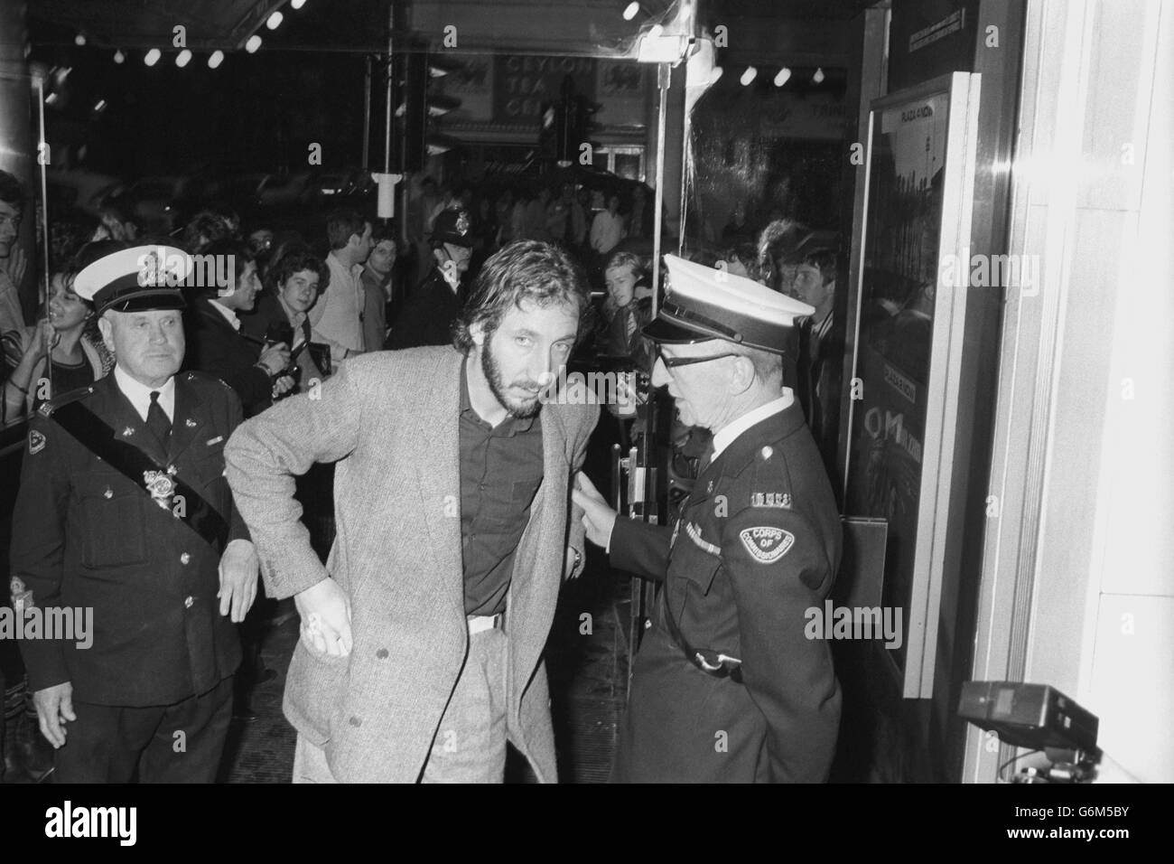Rock star Pete Townshend, of The Who, halted by a commissionaire wanting to see his ticket as he arrived at the Plaza One Cinema in Lower Regent Street, London, to attend the world premiere of Quadrophenia, a film based on The Who's album of the same name. Townshend silently produced his ticket and went in to join the star-studded audience. Stock Photo