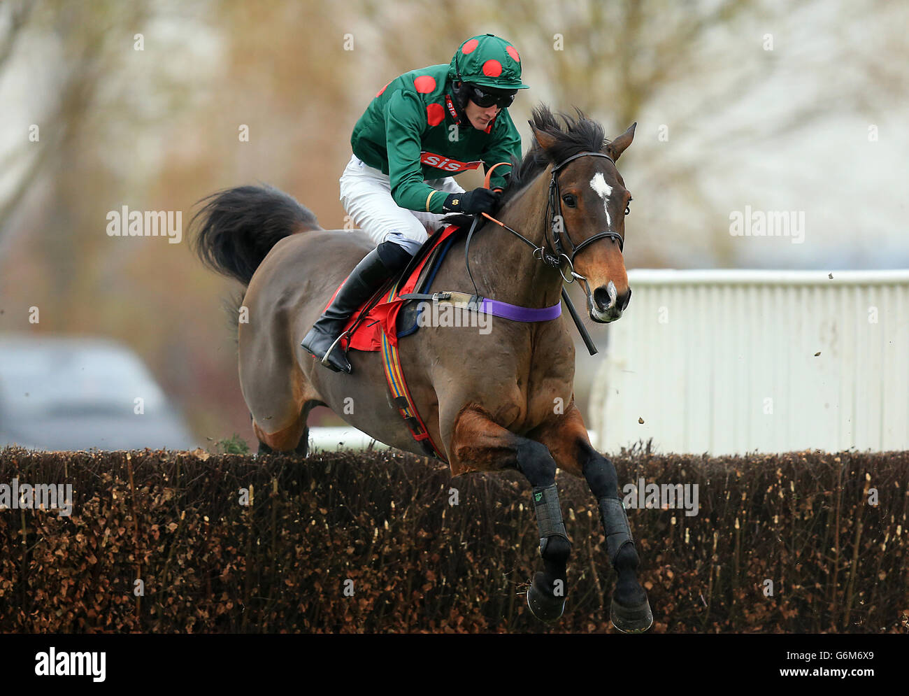 Jockey Josh Hamer on One More Dinar jumps a hedge during the 32 Free Bet At 32Red.com Handicap Chase. Stock Photo