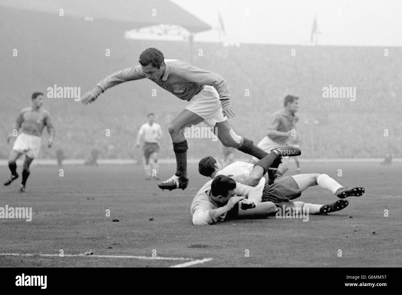 France goalkeeper Claude Abbes goes sprawling with England's Bobby Robson while France's Mustapha Zitouni jumps over the top during an England attack on the French goal in the international at Wembley. Mustapha Zitouni would go on to quit France in 1958 prior to the World Cup Finals to play for his native Algeria. Stock Photo