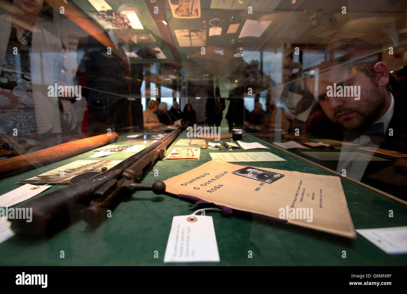 Peter Kavanagh of Active Retirement Ireland views exhibition pieces including a German Mauser rifle, manufactured in 1870, landed at Howth July 26th 1914 aboard the Asgard, by Erskine Childers as part of a major consignment of arms for the Irish Volunteers and a souvenir of the funeral of O'Donovan Rossa, at the launch of an exhibition to mark the centenary of the Irish Citizens Army and Irish Volunteers at the Glasnevin cemetery museum in Dublin. Stock Photo