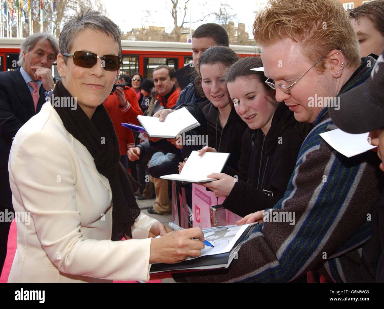 Actress Jamie Lee Curtis signs autographs as she arrives for the premiere of her new film 'Freaky Friday' at the Odeon, Kensington High St in west London. Stock Photo