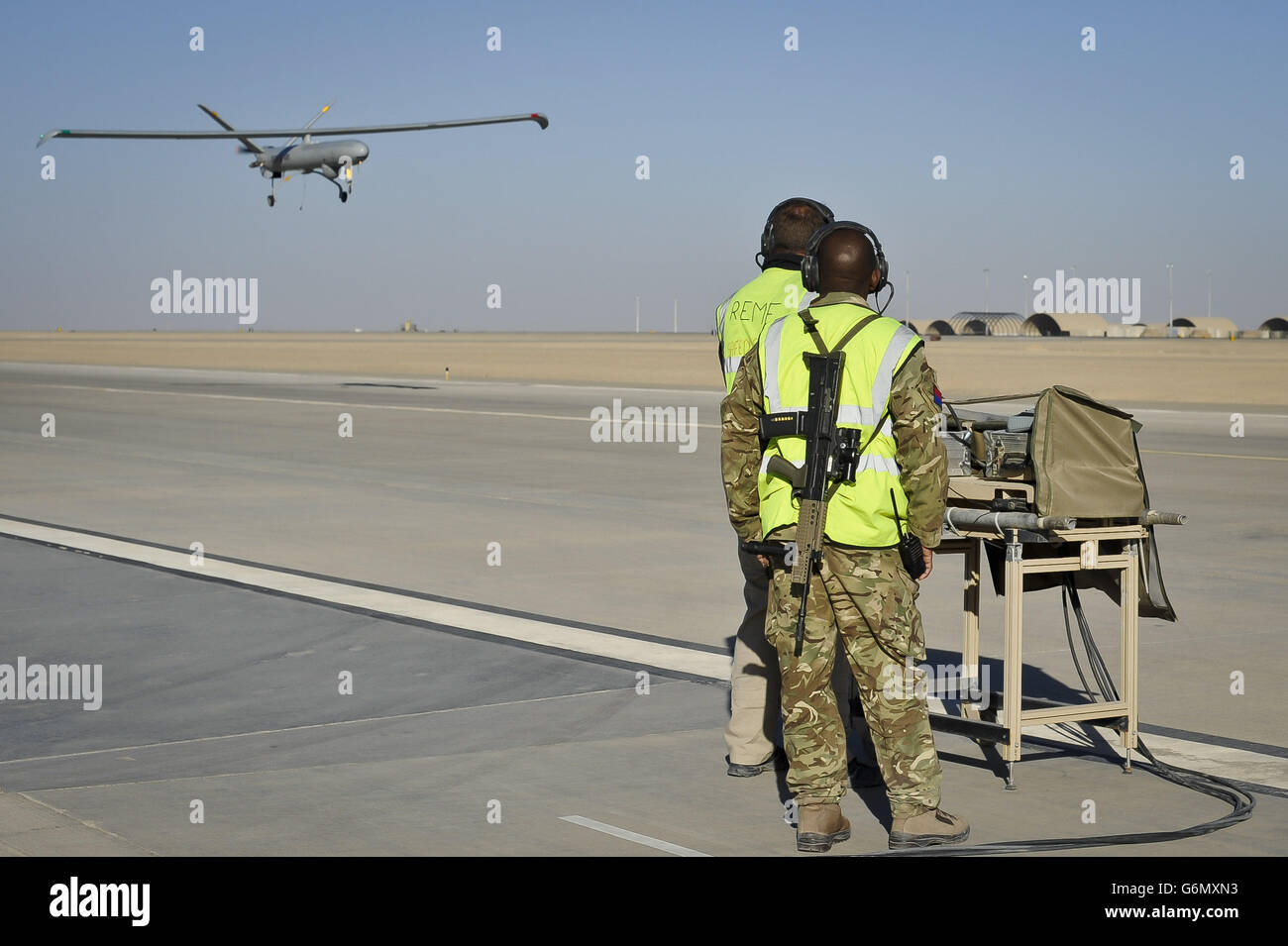 Ground crew remotely control a Hermes 450 Unmanned Aerial System (UAS), which is a remotely controlled reconnaissance aircraft, as it takes off at Camp Bastion airfield, Helmand Province, Afghanistan. Stock Photo