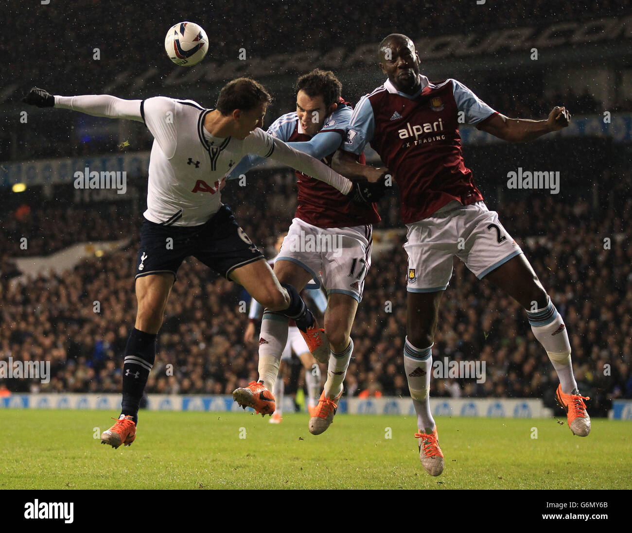 Tottenham Hotspur's Vlad Chiriches goes for header with West Ham United's Joey O'Brien and Carlton Cole during the Capital One Cup match at White Hart Lane, London. Stock Photo