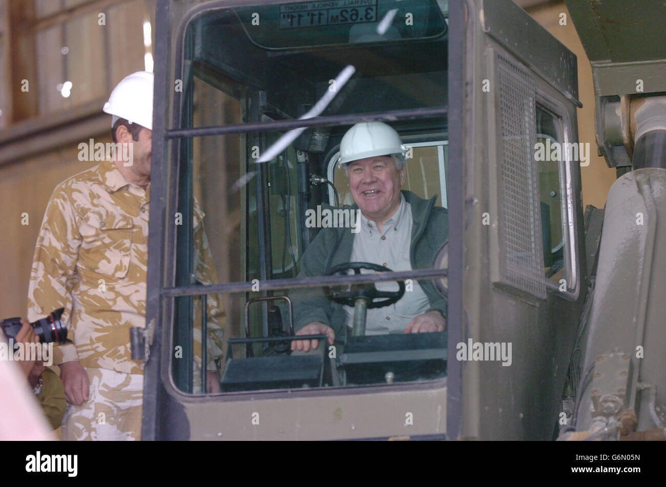 Armed Forces Minister Adam Ingram sits behind the wheel of some lifting equipment during a visit to Shaibah Logistic Base. Ingram was joining Leader of the Opposition Michael Howard and shadow defence secretary Nicholas Soames for the last leg of a tour to raise troops' morale. Stock Photo