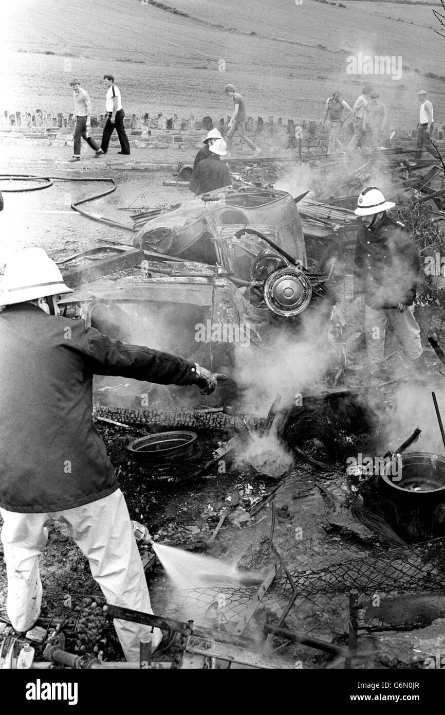 Fireman hose down burning cars during clashes between riot police and