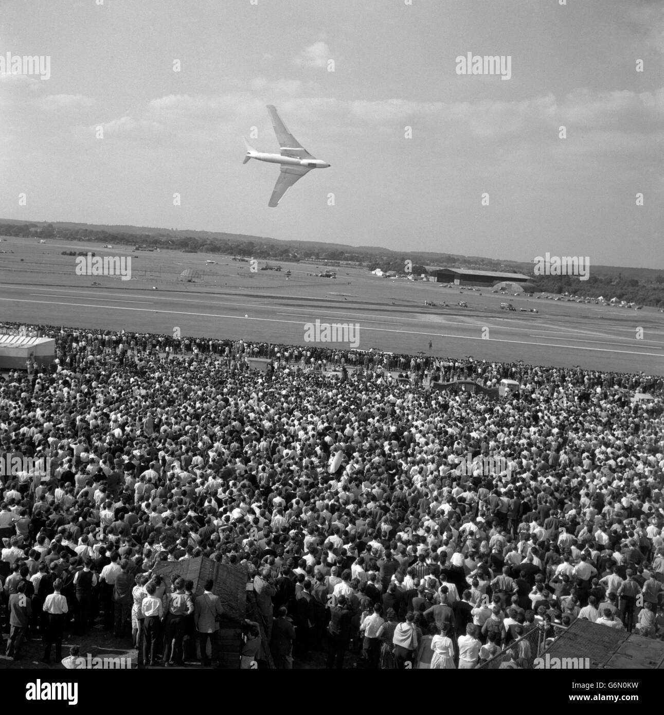 A crowd watching a wheeling Handley Page Victor bomber during the the Society of British Aircraft Constructors' annual Flying Display and Exhibition at Farnborough in Hampshire. Stock Photo