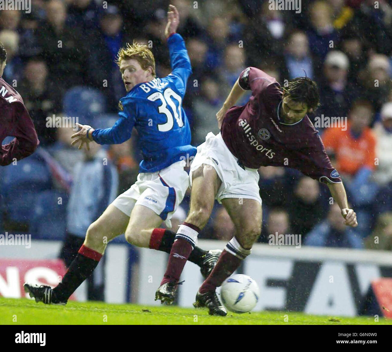 : Rangers player Chris Burke and Hearts player Paul Hartley, during their Bank of Scotland Scottish Premiership match at Rangers' Ibrox Stadium in Glasgow. Stock Photo