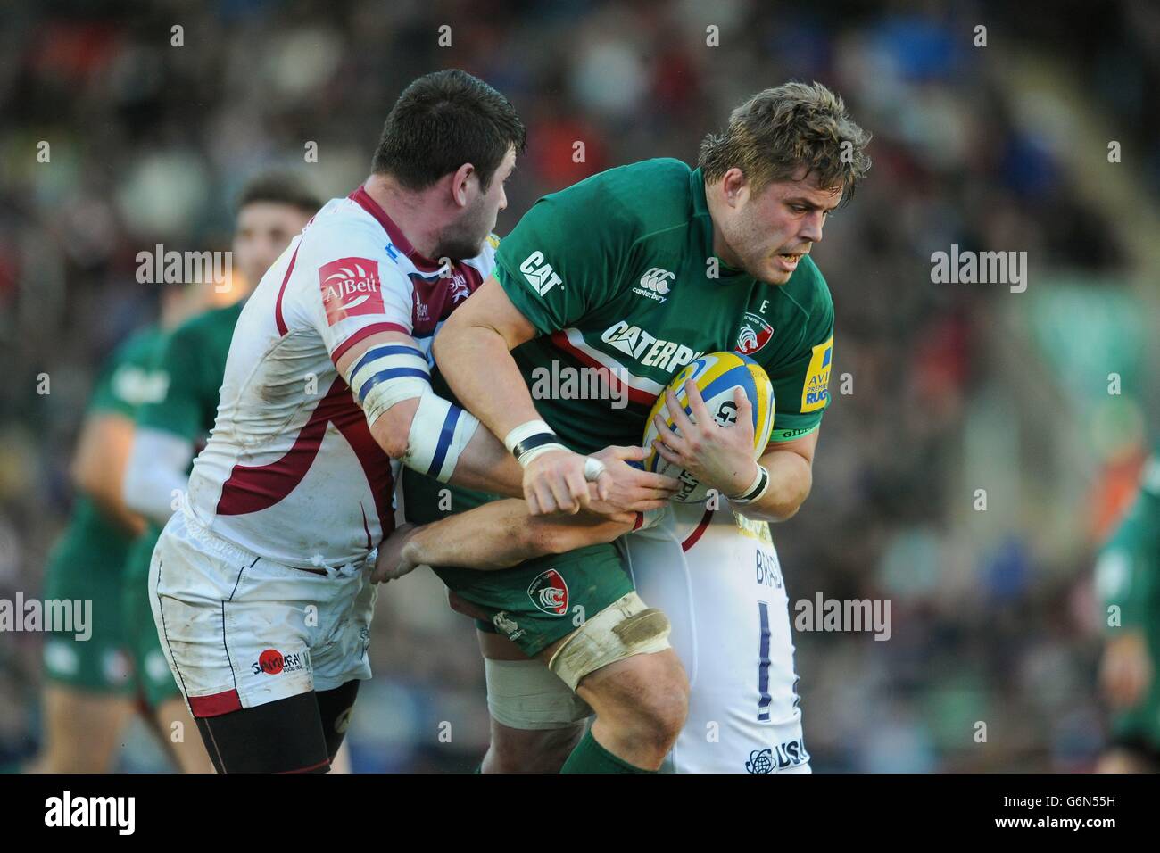 Leicester Tigers' Ed Slater is tackled by Sale Sharks' Marc Jones (left) and Tom Brady (right) during the Aviva Premiership match at Welford Road, Leicester. Stock Photo
