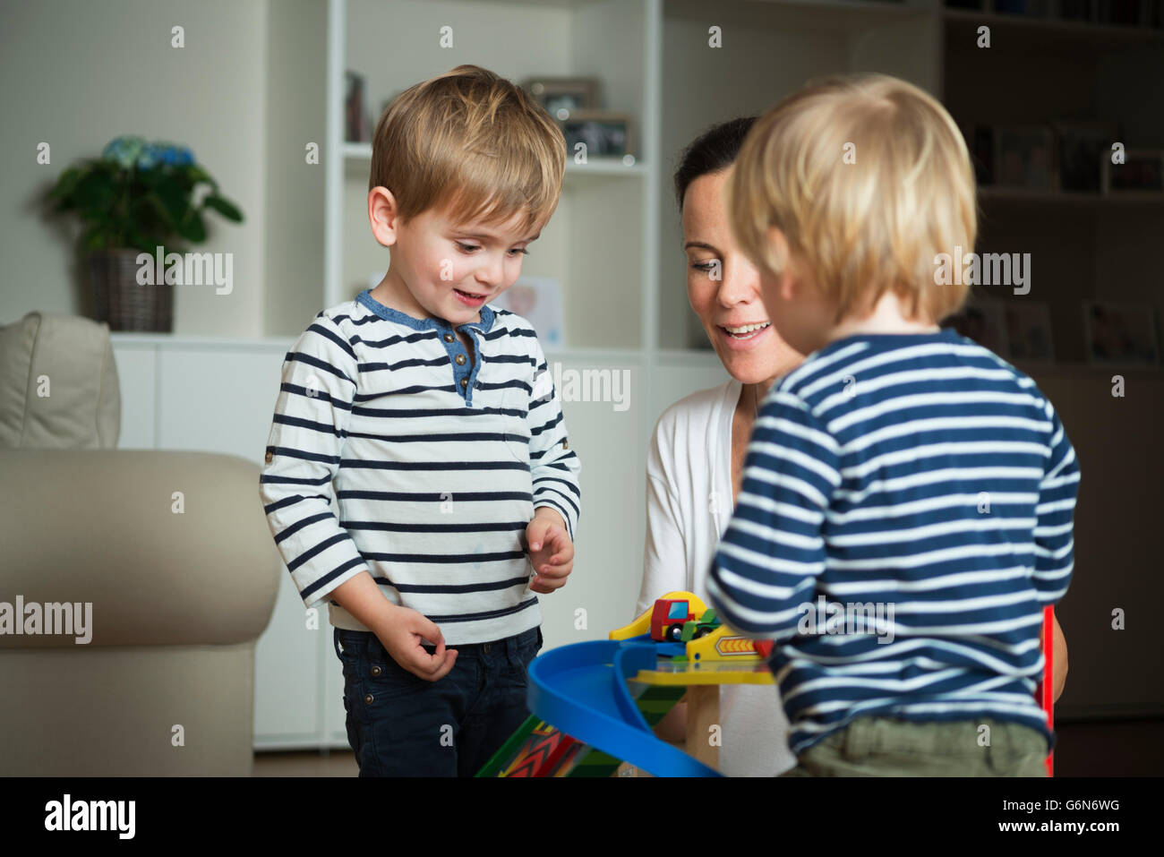 Two little boys playing at home with their mother Stock Photo - Alamy