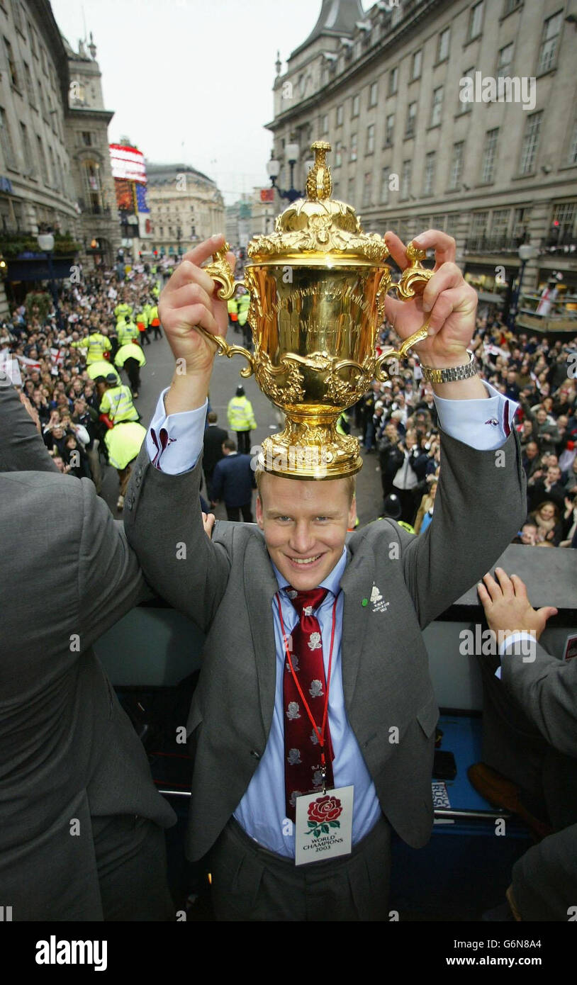England player Stuart Abbott holds the Webb Ellis Cup during the England Rugby World Cup team victory parade in central London. The two open-topped buses arrived outside the National Gallery to a rapturous welcome from thousands of fans. The square was a sea of red and white flags as the nation's heroes waved to fans. Stock Photo