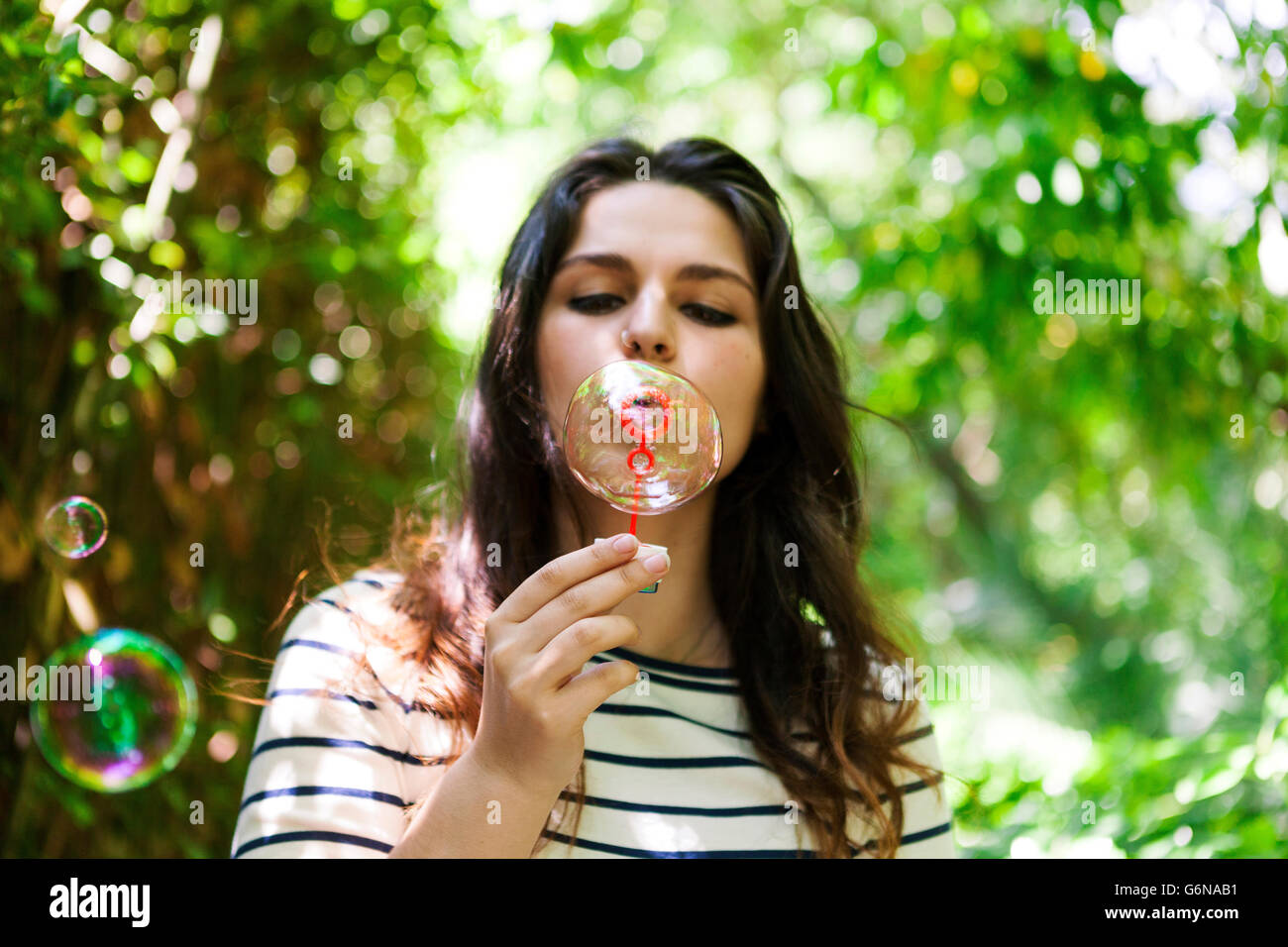 Young woman blowing soap bubbles Stock Photo - Alamy