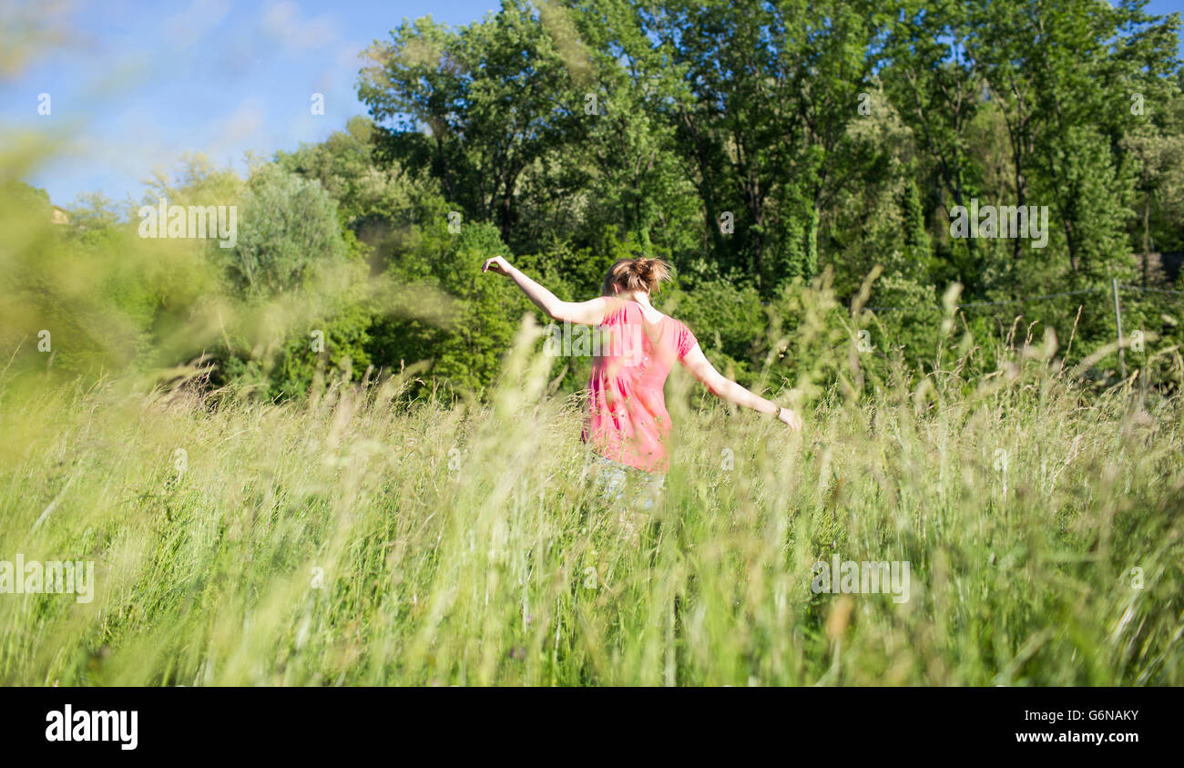 Back view of teenage girl on a meadow Stock Photo - Alamy