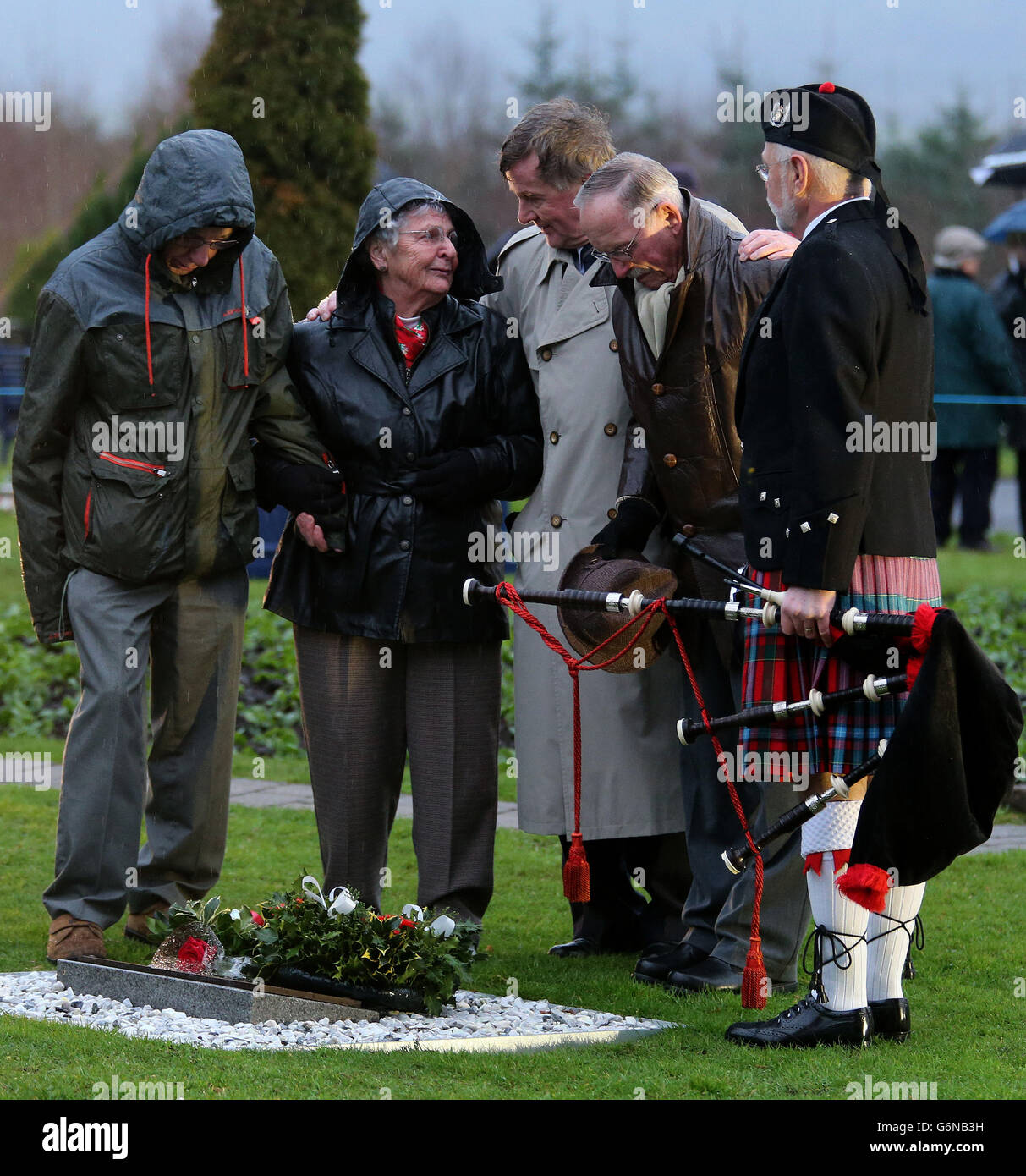 Relatives Marie Klein (second left) with husband Frank Klein (second right) parents of Patricia Ann Klein, in the garden of remembrance following a memorial service to mark the 25th anniversary of the Lockerbie bombing at the memorial site at Dryfesdale Cemetery in Lockerbie. Stock Photo