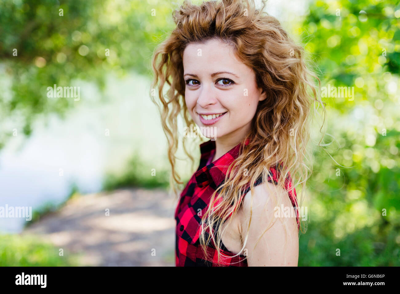 Portrait of smiling woman with curly hair Stock Photo - Alamy