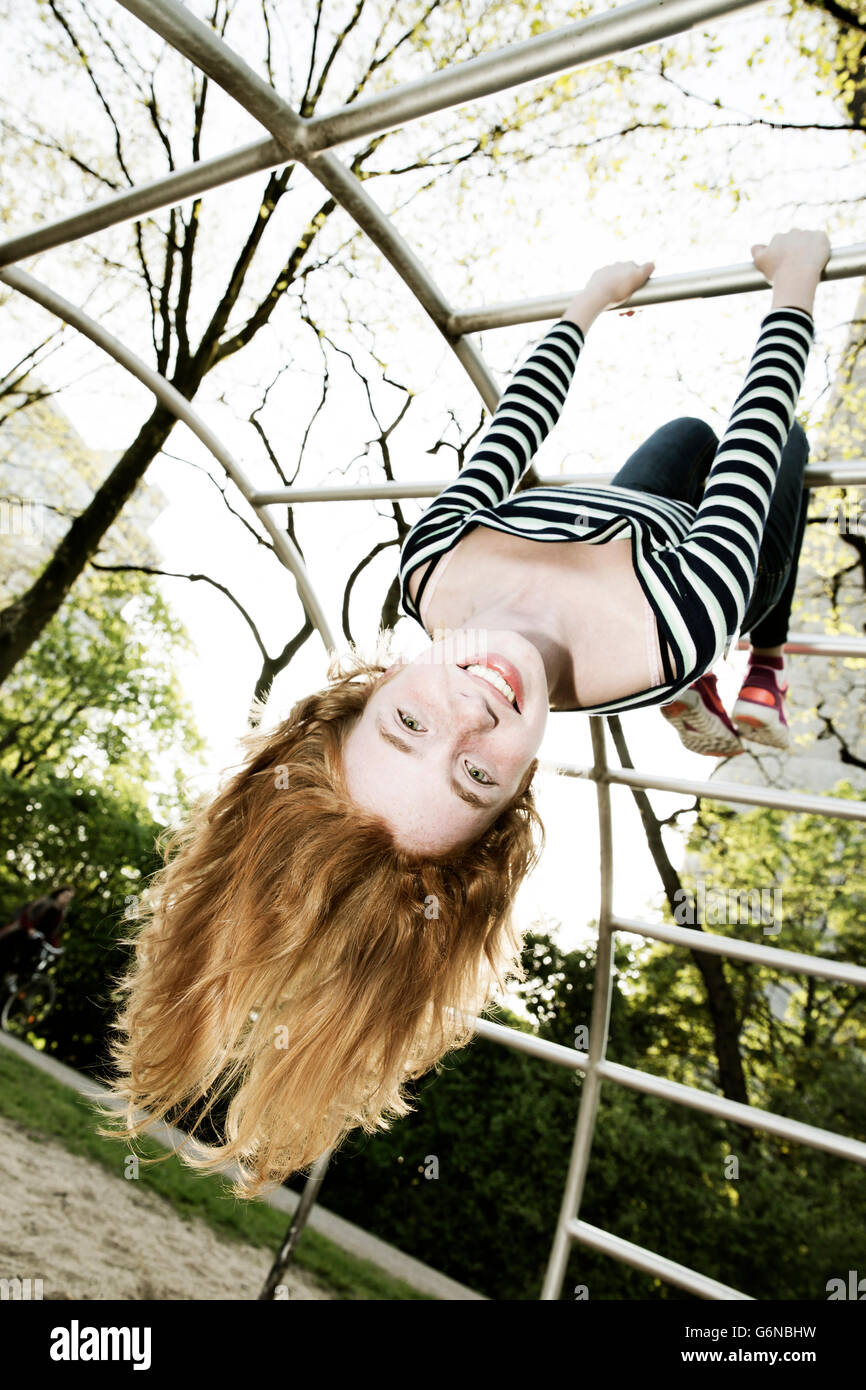 Portrait of smiling girl hanging upside down on jungle gym Stock Photo -  Alamy